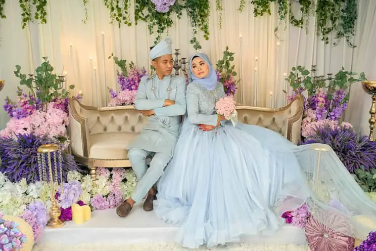 Muslim bride and groom sat on ceremonial wedding chair