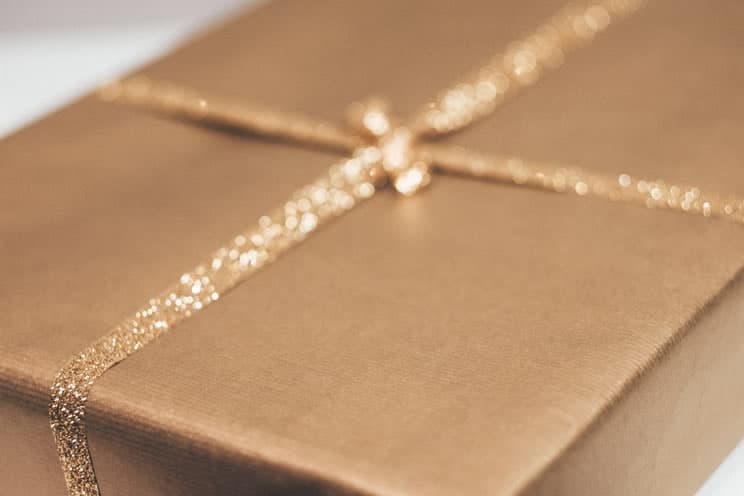 Gold envelope wrapped in a ribbon with a bow